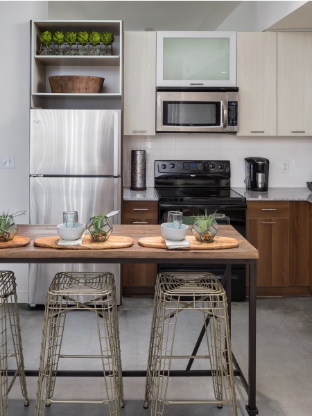 View of the Kitchen at 935M Apartments, Showing Island, Appliances, and View of Hallway