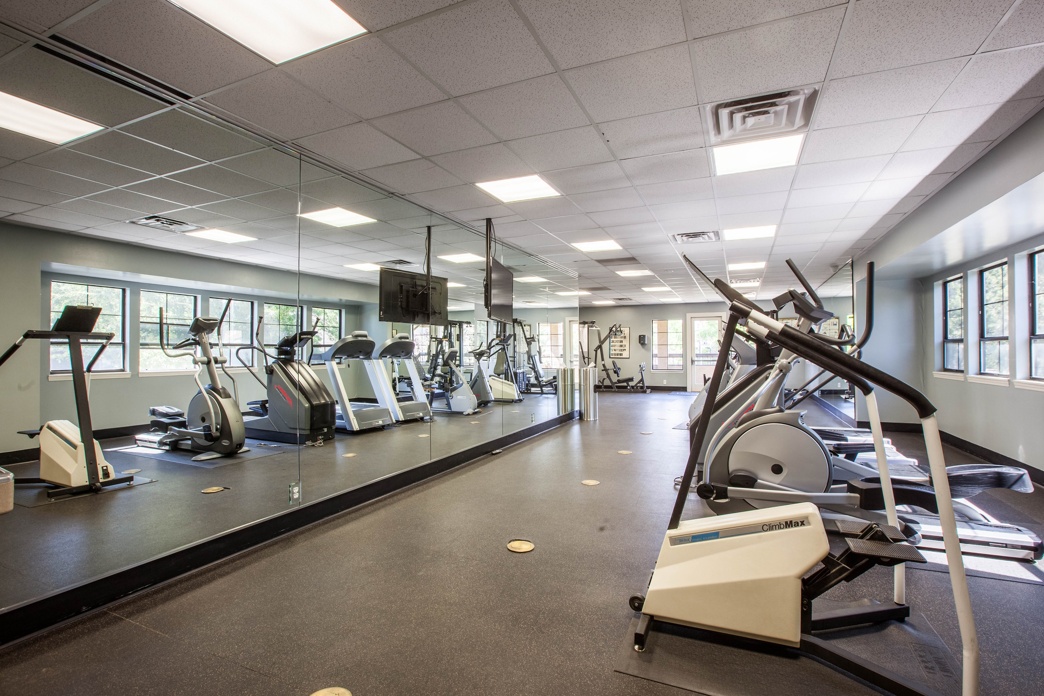 Enjoy Our Fitness Studio, With View of Cardio Machines, Cable Machines, and TV at Cottonwood Apartments