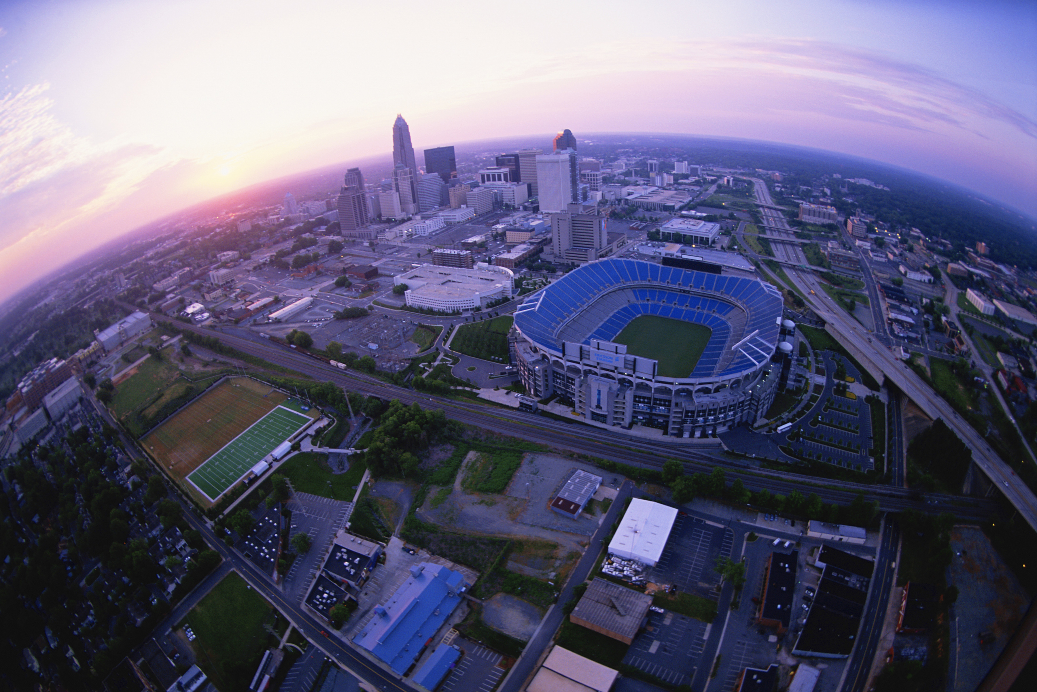 Arial view of Bank of America stadium during sunset, showing the stadium and surrounding city at Bank of America Stadium