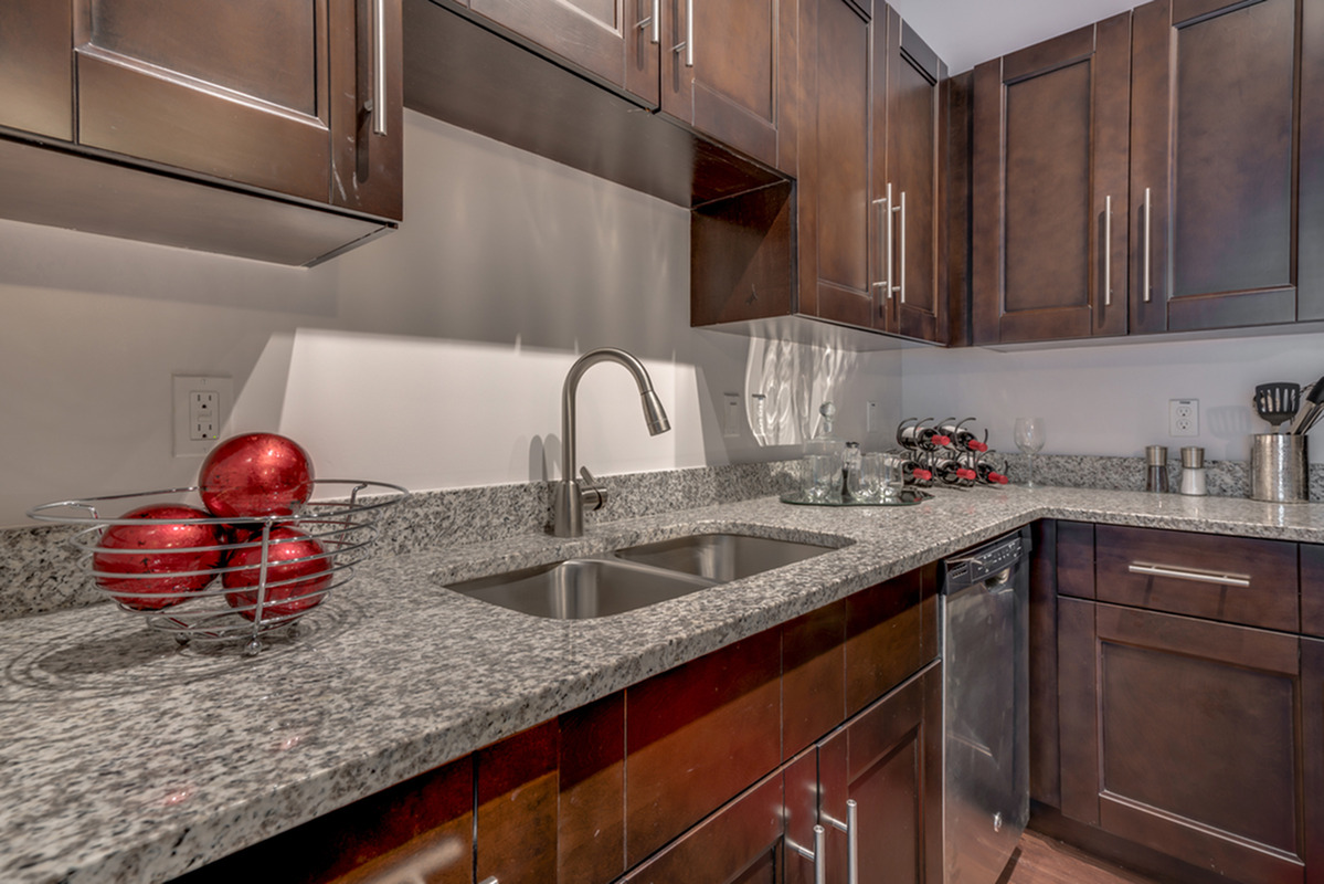 View of Kitchen, Showing Granite Countertop, Custom Cabinetry, and Dishwasher at The Marq Highland Park Apartments