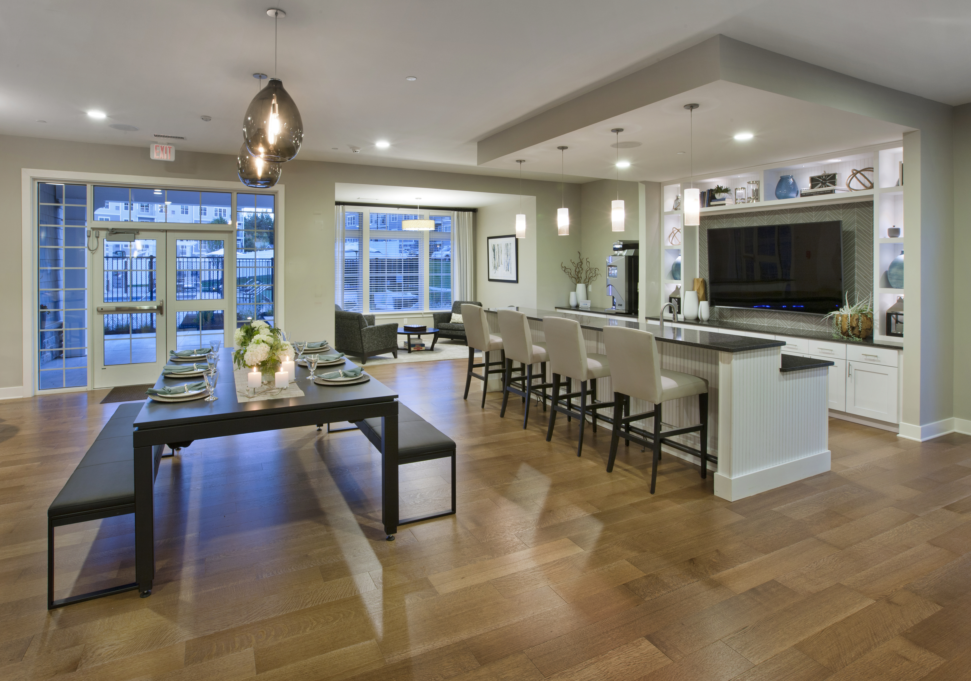 View of Resident Clubhouse, Showing Dining Table, Benches, Kitchen Area, Bar Stools, and Sitting Area at Parc Westborough Apartments