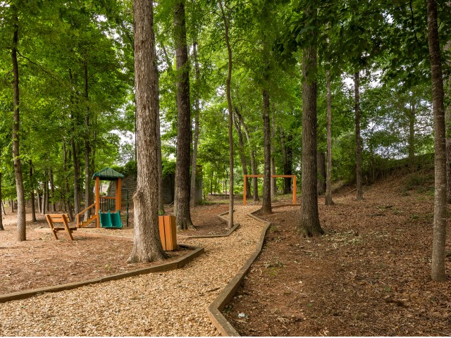 View of Walking Path, Showing Playground and Trees at Retreat at Peachtree City Apartments