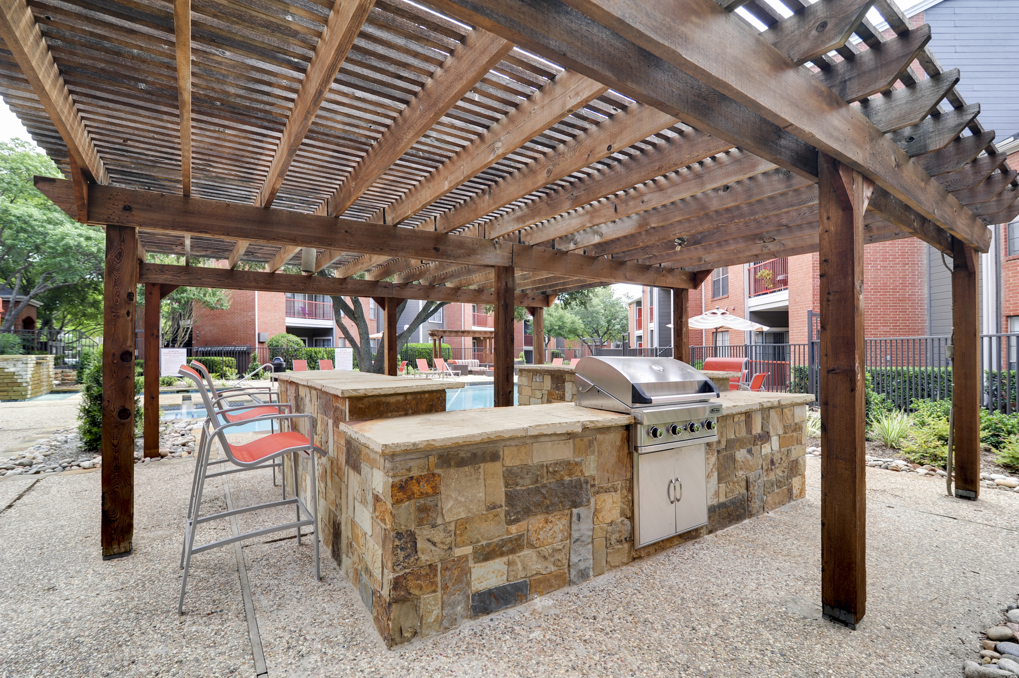 View of Grilling Lounge, Showing Grill, Serving Area, Chairs, and Pergola at 4804 Haverwood Apartments