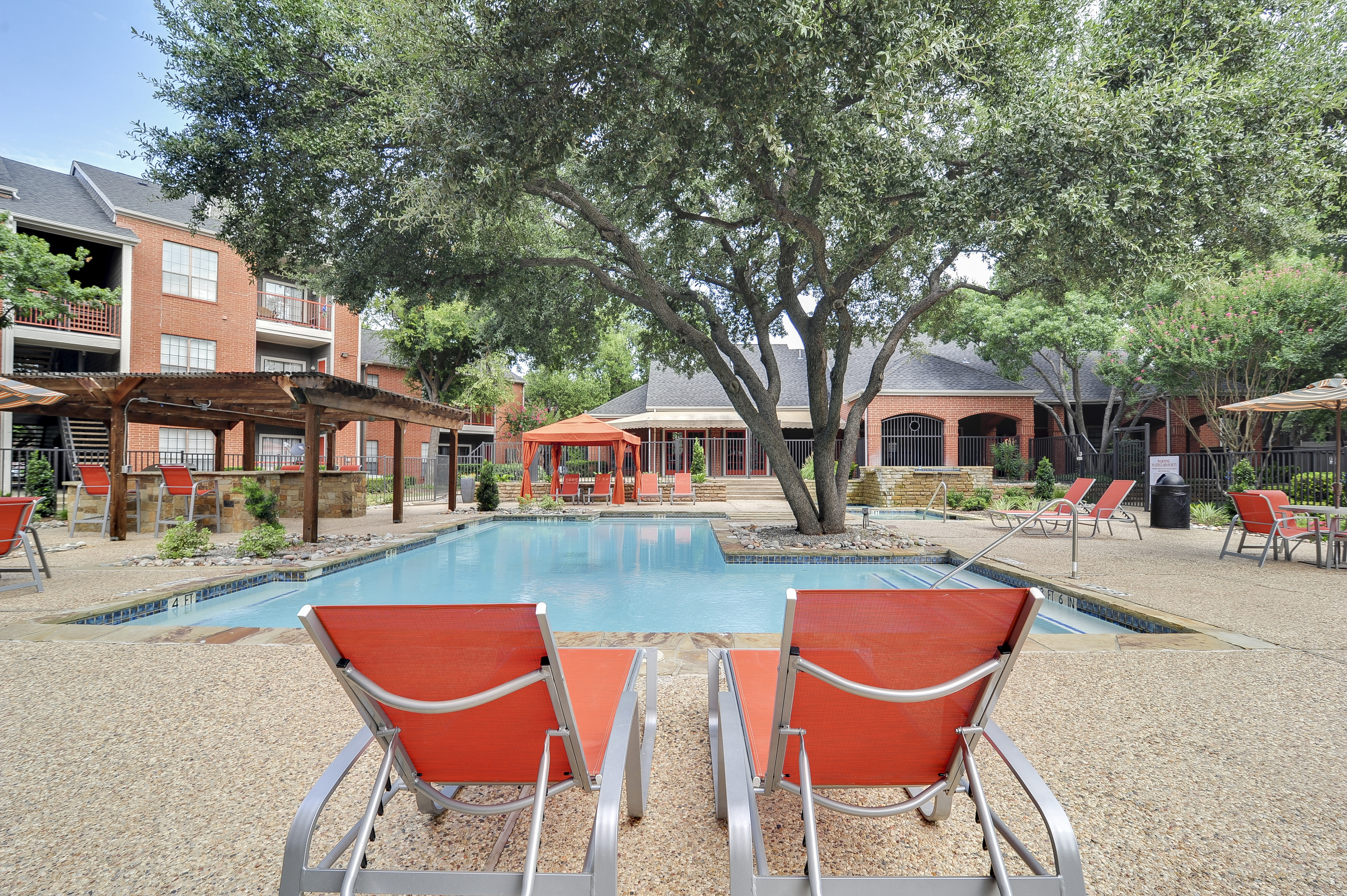 View of Pool Area, Showing Loungers, Grilling Areas, and Building Exteriors at 4804 Haverwood Apartments