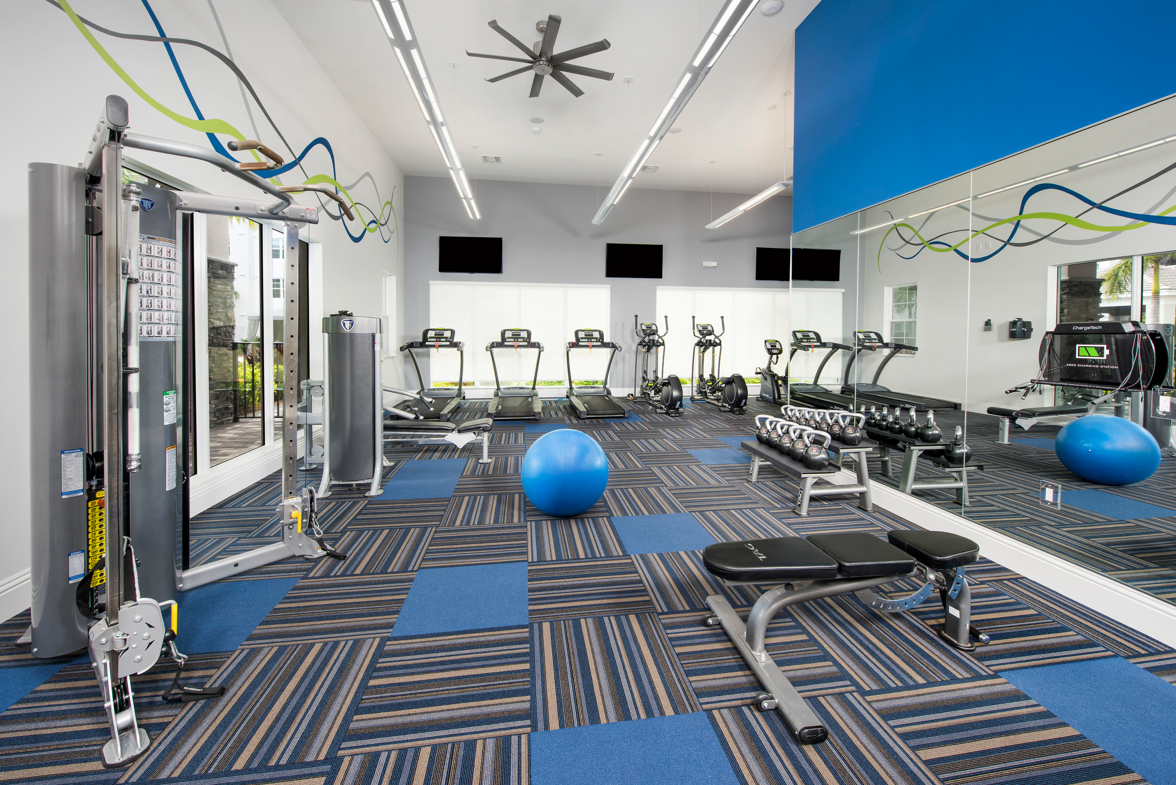 View of Fitness Center, Showing Weight Bench, Exercise Ball, Cardio in Back, and Cable Weight Machine at Cottonwood West Palm Apartments