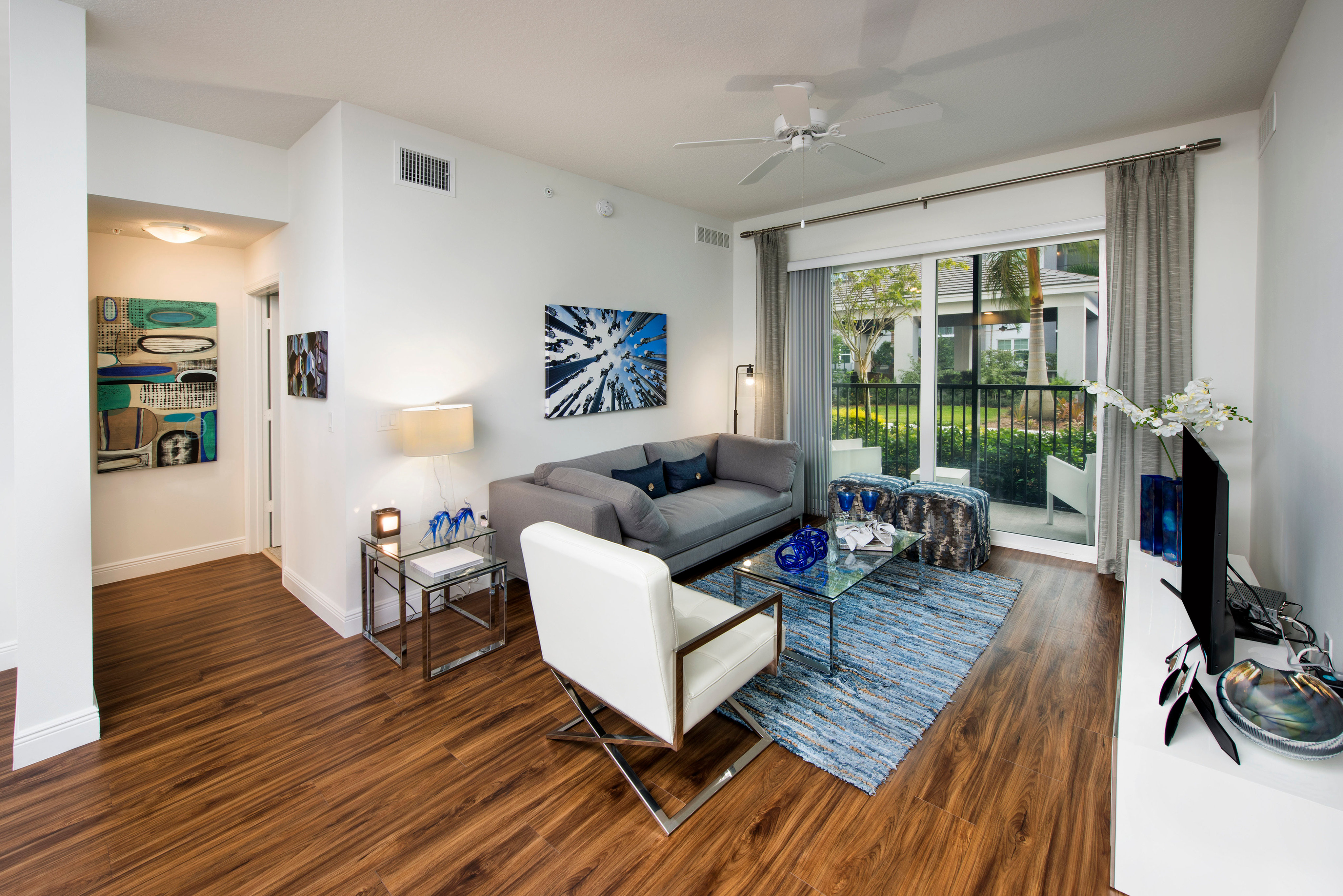 View of Living Room, Showing Couch, Accent Chairs, and View of Private Patio at Cottonwood West Palm Apartments