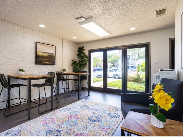 View of Wi-Fi Café, Showing French Doors, Seating Area, High Top Tables With Charging Stations and Chairs at Solara Apartments