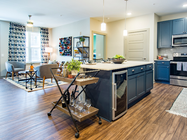 Enjoy Our Kitchen, With View of Chef\'s Island, Wine Refrigerator, and Hardwood-Inspired Flooring at Alton Optimist Park Apartments