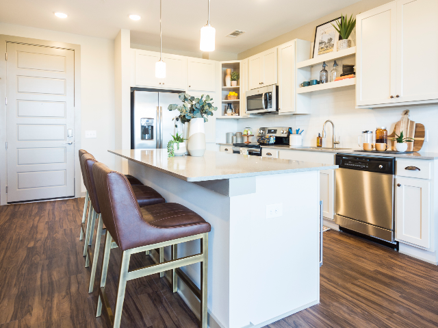 View of Kitchen at Alton Optimist Park showing White Cabinets, Kitchen Island, and Stainless Steel Appliances