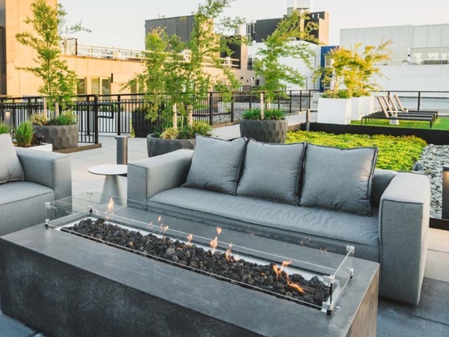 Rooftop resident lounge space with multiple tables and stylish lighting